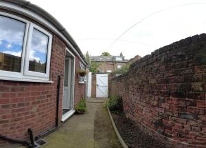 a brick wall next to a house with a door at 2-bed terraced home - 5 min walk to the City Walls in York