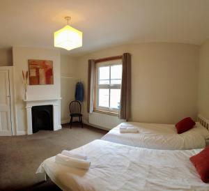 two beds in a room with a fireplace at 2-bed terraced home - 5 min walk to the City Walls in York