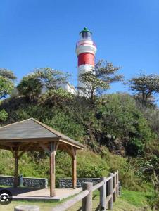 a lighthouse with a gazebo in front of it at Relais des ô vives in Sainte-Suzanne +2 photos