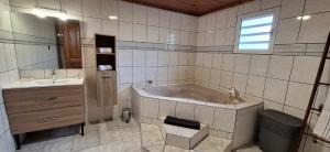 a large bathroom with a tub and a sink at Relais des ô vives in Sainte-Suzanne