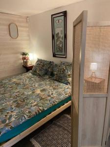 ein kleines Schlafzimmer mit einem Bett und einem Spiegel in der Unterkunft Studio in Condom