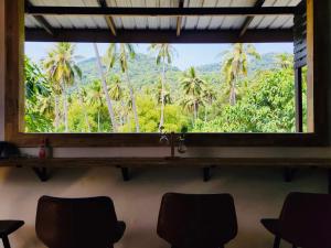 a window in a room with a view of palm trees at Koh Tao Silver Na’s Hostel in Ko Tao