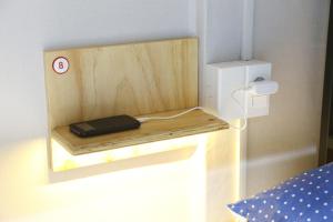 una estantería de madera con un teléfono en un dormitorio en Ganse Guesthouse en Jeju