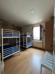 a room with two bunk beds and a window at Albergue Mayor in Sarria