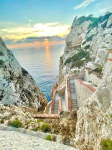eine Treppe auf einer Klippe neben dem Meer in der Unterkunft Sardinia SeaBreeze Villa IUN R2178 in Castelsardo