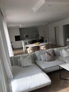 a living room with a white couch and a table at Stan- och strandnära poolvilla. in Halmstad