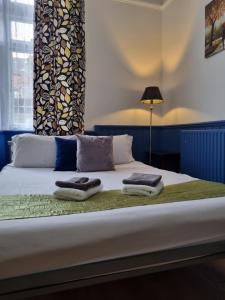 a bed with two towels on top of it at The Windmill in London