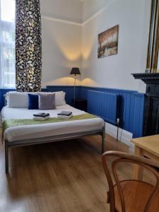 1 dormitorio con 1 cama, 1 mesa y 1 silla en The Windmill, en Londres