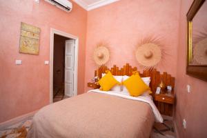 1 dormitorio con 1 cama grande con almohadas amarillas en Riad Miss Caracal, en Marrakech