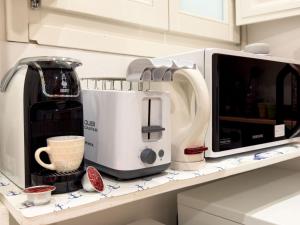 a kitchen counter with a coffee maker and a microwave at Flamingo Mini monolocale in Cagliari