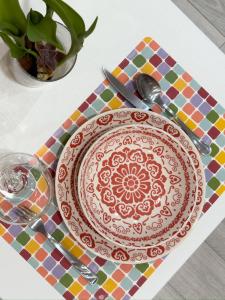 a plate with a pattern on a table with a glass at Flamingo Mini monolocale in Cagliari