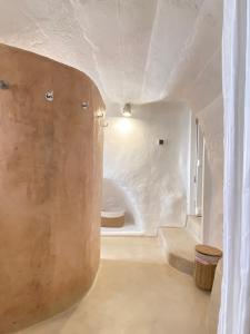 een badkamer met een grote witte kamer met een houten muur bij Renovated house in the historic center in Mojácar