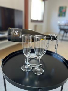 La Terasse des Vignes - Maison 2 Chambres - 4 Personnes في Blienschwiller: كأسين من النبيذ على طاولة مع زجاجة من النبيذ