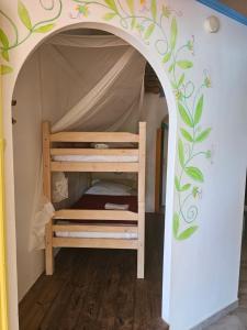 a bunk bed in a room with a wall with a mural at KANOUAN in Deshaies +9 photos