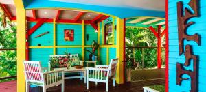a colorful house with a table and chairs on a porch at KANOUAN in Deshaies