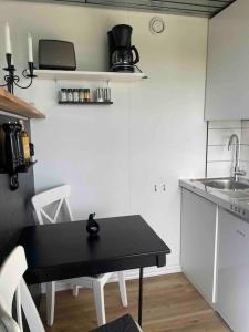 a small kitchen with a black table and a sink at Container in Hammenhög +12 photos