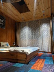 1 dormitorio con 1 cama en una habitación con paredes de madera en HOMESTAY ĐỐM HOUSE, en Hoat