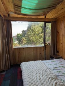 um quarto com uma cama e uma grande janela em HOMESTAY ĐỐM HOUSE em Hoat