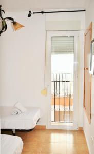 a room with a bed and a door with a balcony at Cozy Tourist Bungalow in Benidorm