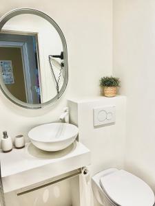 een witte badkamer met een wastafel en een spiegel bij De Zandkorrel - Amazing seaview in Wenduine