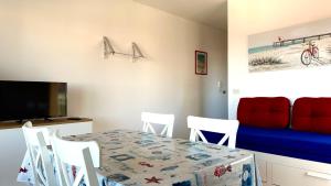 a dining room with a table and a couch at SE063 - Marzocca, delizioso bilocale comodo al mare in Marzocca di Senigallia