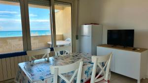 a dining room with a table and a refrigerator at SE063 - Marzocca, delizioso bilocale comodo al mare in Marzocca di Senigallia
