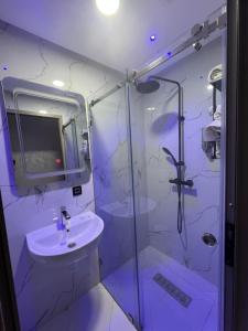 bagno bianco con lavandino e doccia di Appartement Wow ad Al-Ḥoseyma