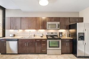 uma cozinha com armários de madeira e electrodomésticos de aço inoxidável em 1B1B Modern Chic in DT Pittsburgh VALET GYM WIFI em Pittsburgh