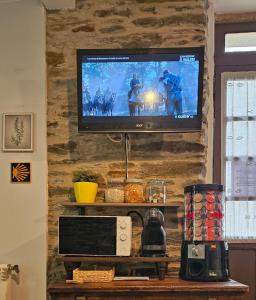 a television hanging on a stone wall at Albergue Mayor in Sarria