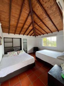 ロス・サントスにあるMesa de los Santos La Mantilissaのベッドが2つあり、天井が木製の寝室