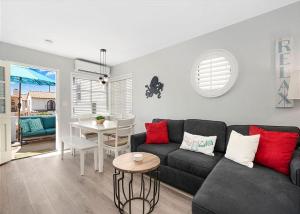 uma sala de estar com um sofá preto e uma mesa em Balboa Paradise - Renovated Coastal Haven em Newport Beach