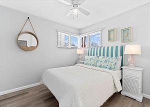 a white bedroom with a bed and a mirror at Balboa Paradise - Renovated Coastal Haven in Newport Beach