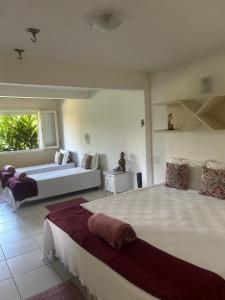 a large bedroom with two beds and a couch at Spazio Buzios Guesthouse in Búzios