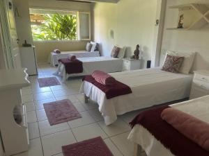 a hotel room with two beds and a window at Spazio Buzios Guesthouse in Búzios