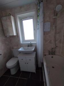baño con aseo y lavabo y ventana en Edinburgh Villa 3 bed Rooms House in Edinburgh - Private parking, en Edimburgo