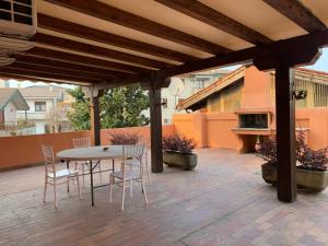 a patio with a table and chairs under a wooden pergola at Apartment Villa valmarana De Toni in Creazzo