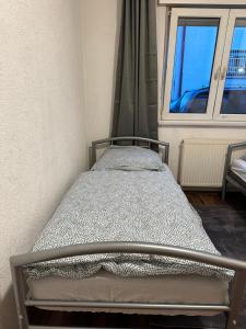a small bed in a room with a window at 2 Zimmer mit 4 Betten (Wohnung Apartment) in Bruchsal