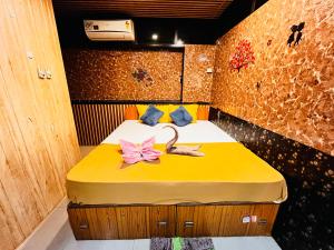 Una habitación con una cama con dos flores rosas. en Small Daddy Guest House Calangute 1 en Calangute