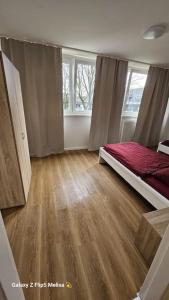 een slaapkamer met een bed en een houten vloer bij Sonnenschein-Oase ,Apartment in Marl