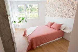 a white bedroom with a bed and a window at Mareas de Carril a 50m de la playa in Vilagarcia de Arousa