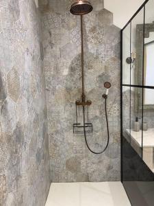 La salle de bains est pourvue d'une douche et d'un mur en pierre. dans l'établissement Authentique moulin à eau du ⅫⅠe siècle, à La Vernelle