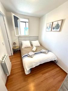 a small bedroom with two beds in a room at Escale au Sud, un appart les pieds dans l eau :) in Le Barcarès