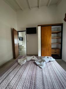 um quarto com uma cama grande com duas almofadas em La Francesca-cabañas em Merlo