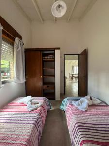 two beds sitting next to each other in a room at La Francesca-cabañas in Merlo