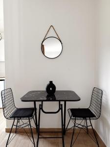 a table with two chairs and a mirror on a wall at Danin apartmani in Bar