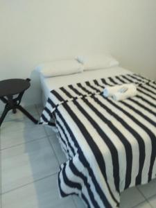 een bed met een zwart-wit gestreepte deken bij 17 on Driffield in East London