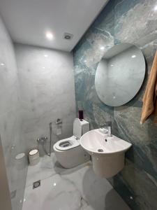 y baño con aseo, lavabo y espejo. en Panoramic House en Bakú