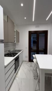 eine weiße Küche mit einem Tisch und einer weißen Arbeitsplatte in der Unterkunft Ficodindia in Pozzallo
