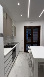 a white kitchen with a table and a white counter top at Ficodindia in Pozzallo