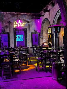 a restaurant with tables and chairs in a room with purple lights at CASA REGINA Hotel - Cantina SMA in San Miguel de Allende